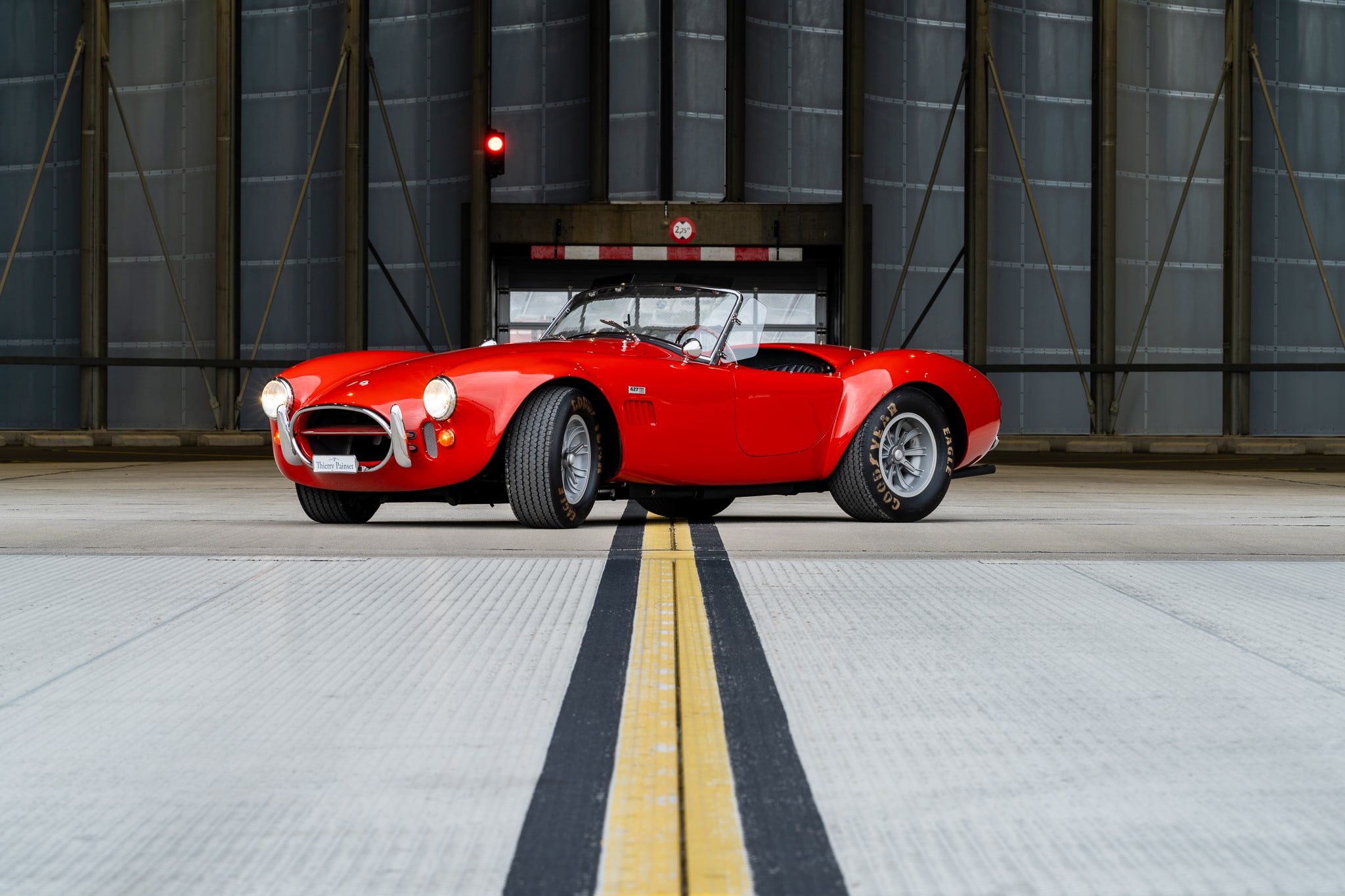 AC Cobra rouge photographiée dans un hangar